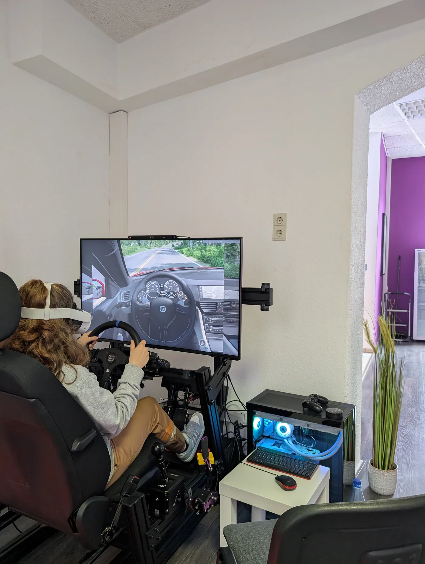 Jugendliche fährt am Simulator mit VR-Brille
